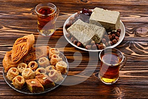 Assorted traditional eastern desserts with tea on wooden background.