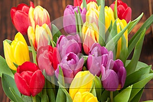 Assorted Tulips Bouquet. Burned Wooden Background. Copy Space