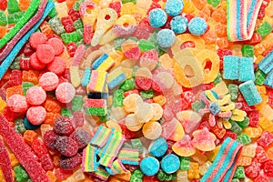 Assorted variety of sour candies includes extreme sour soft fruit chews, keys, tart candy belts and straws