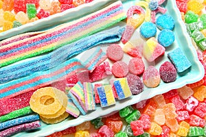 Assorted variety of sour candies includes extreme sour soft fruit chews, keys, tart candy belts and straws