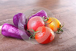 Assorted vegetable with purple exotic color bell peppers and tomatoes on stone background.