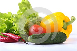 Assorted vegetables, fresh bell pepper, tomato, chilli pepper, cucumber and lettuce isolated on white background