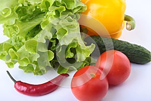 Assorted vegetables, fresh bell pepper, tomato, chilli pepper, cucumber and lettuce on white background