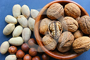 Assorted Walnuts, macadamia nuts and pecans close-up on wooden table