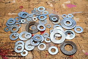 Assorted washers on  wooden workbench stained grunge textured surface