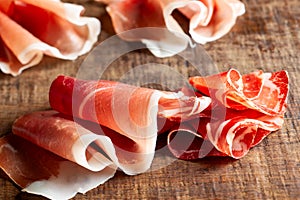 Assorti of sliced jamon, salami, ham  on wooden background