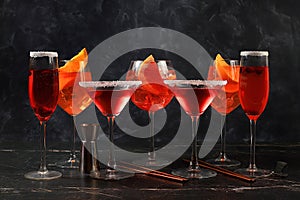 Assortment of alcoholic cocktail Aperol spritz, champagne and red martini in glasses on a dark background, bar concept,