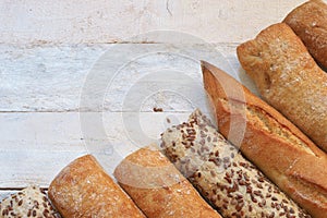 Assortment of baked bread on a white wood table.