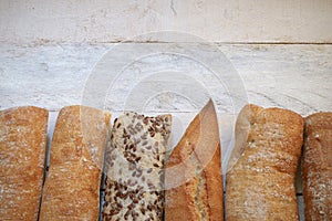 Assortment of baked bread on a white wood table.