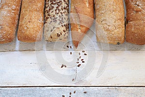 Assortment of baked bread on a white wood table.