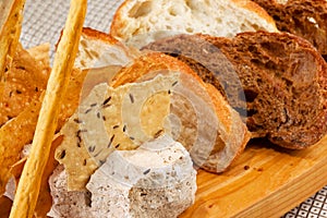 Assortment of baked bread on wooden plate