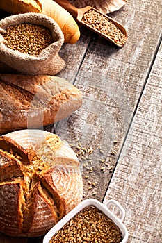 Assortment of baked bread on wooden table background