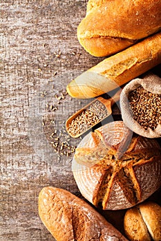 Assortment of baked bread on wooden table background