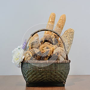 Assortment of baked goods in basket isolate on grey background