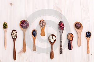 Assortment of beans and lentils in wooden spoon set up on wooden