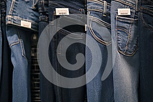 Assortment of blue and black jeans displayed in shopping center