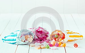 Assortment of candies in three bags over a table