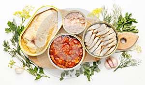 Assortment of canned fish on a white background in tins. Processed food