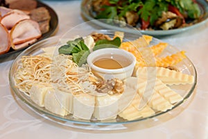 Assortment of cheese sliced on a platter.