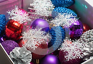Assortment of Christmas decorative balls, pine cones and snowflakes in a box.