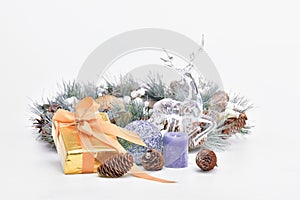 An assortment of Christmas ornaments with a gift box and an out focus pine cone wreath