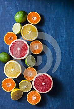 Assortment of citrus fruits on a blue background, top view. Oranges, grapefruit, tangerine, lime, lemon - organic fruits, vegetari