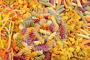 Assortment of colored uncooked Italian pasta close up