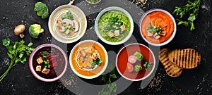 Assortment of colored vegetable cream soups. Dietary food. On a black stone background. Top view. photo