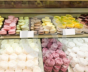 Assortment of Colorful macarons and meringue for sale in shop. sweets and cakes in candy shop, cafe showcase. Traditional french