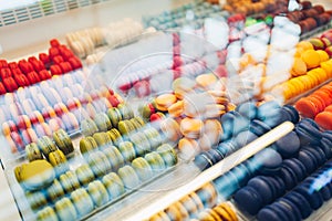 Assortment of colorful macaroons on cafe showcase. Variety of macaron flavours. Sweet almond cakes in store