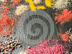 Assortment of colorful spices on the graphite background