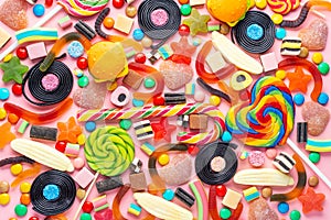 Assortment of colourful lollipops, fruit bonbon and candies on pink like background