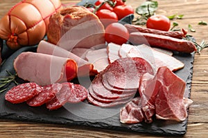 Assortment of delicious deli meats on slate plate