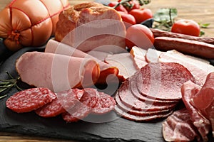 Assortment of delicious deli meats on slate plate photo