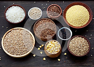 Assortment of different cereals and seeds in bowl: wheat, oats, barley, rice, millet, buckwheat