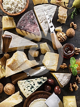 Assortment of different cheese types on stone background. Top view