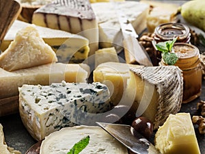 Assortment of different cheeses with olives and jams. Food background