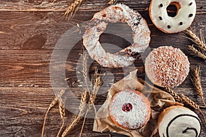 Assortment of different kind of cereal bakery: donuts and cracknel on old wooden background photo