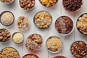 Assortment of different kinds cereals placed in ceramic bowls on table