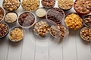 Assortment of different kinds cereals placed in ceramic bowls on table