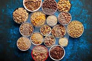 Assortment of different kinds cereals placed in ceramic bowls on table