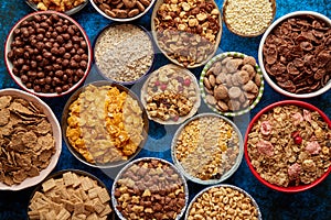 Assortment of different kinds cereals placed in ceramic bowls on table