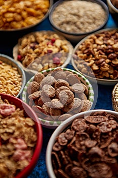 Assortment of different kinds cereals placed in ceramic bowls on table