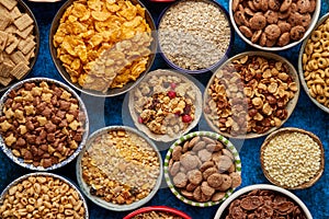 Assortment of different kinds cereals placed in ceramic bowls on table