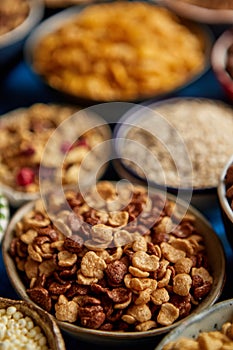 Assortment of different kinds cereals placed in ceramic bowls on table