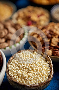 Assortment of different kinds cereals placed in ceramic bowls on table