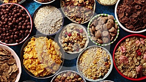 Assortment of different kinds cereals placed in ceramic bowls on table