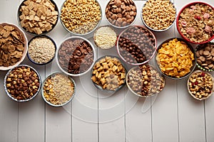 Assortment of different kinds cereals placed in ceramic bowls on table