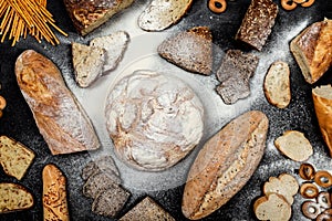 Assortment of different types of bread on a black background. Top view