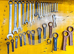 Assortment of do it yourself tools hanging in a yellow wall